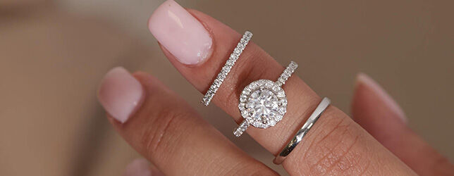 Oval halo diamond engagement ring with pavé setting and matching gold bands